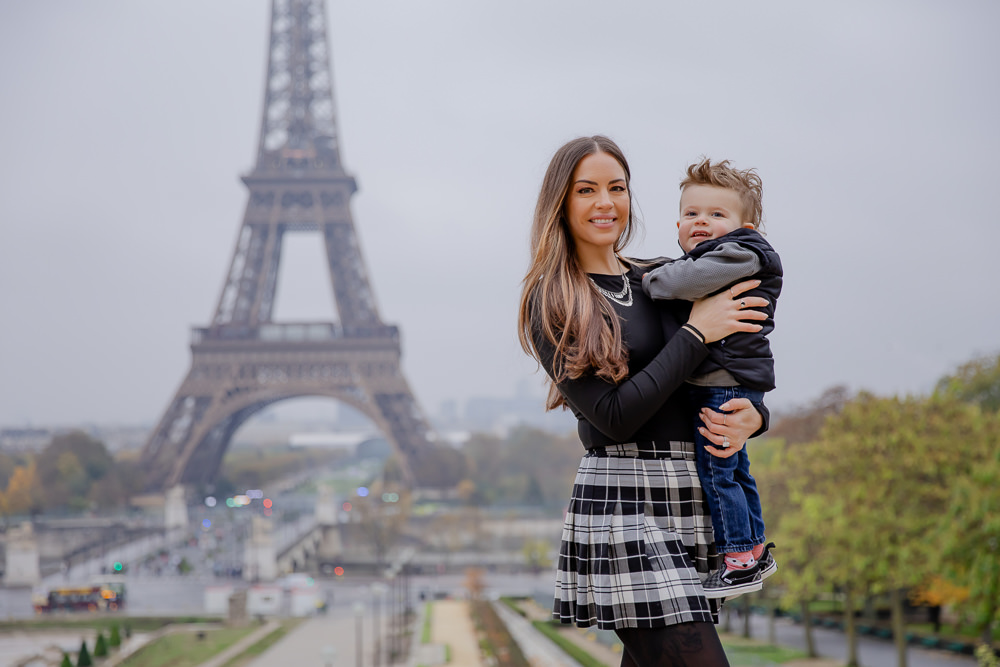 Mother posing with son at Eiffel Tower for family photographer Lena