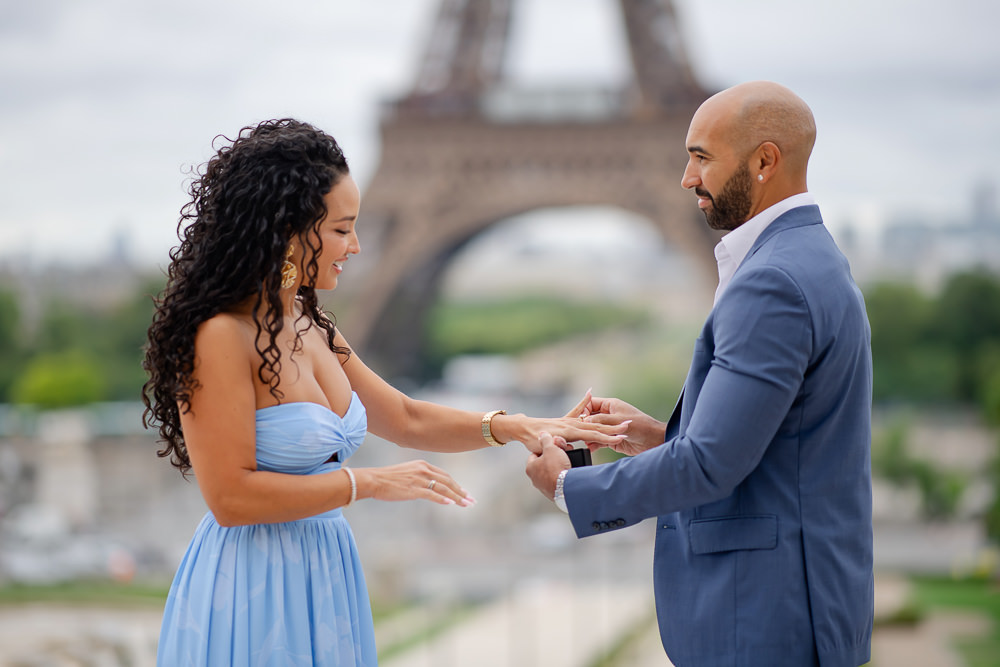 Groom-to-be placing the engagement ring on his fiancée's finger at Trocadéro after a surprise proposal, by Odrida